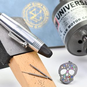 flex shaft drill for jewelry making with flush set pendant in back ground and drill bits for jewelry making in foreground