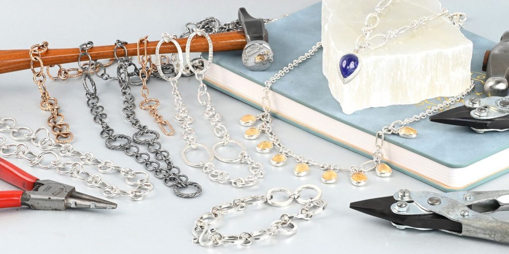 Handmade chains with a hammer top left on a Metalsmith Academy notebook