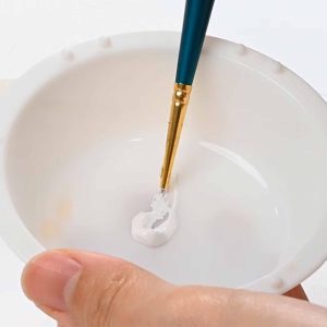 Mixing paint with paintbrush for rendering diamonds in jewellery design