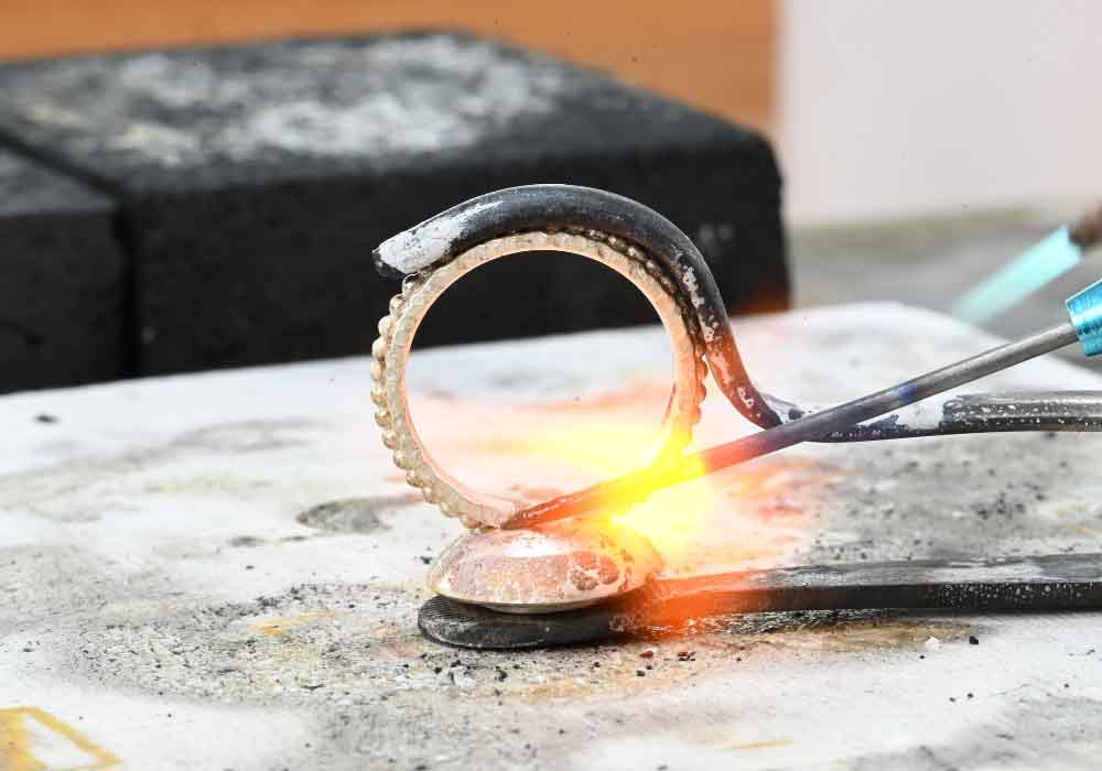 Soldering a setting to a ring band with a smith little torch